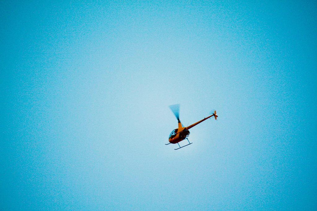 Helicopter flying overhead representing the loud noises a community cat learns to handle outdoors